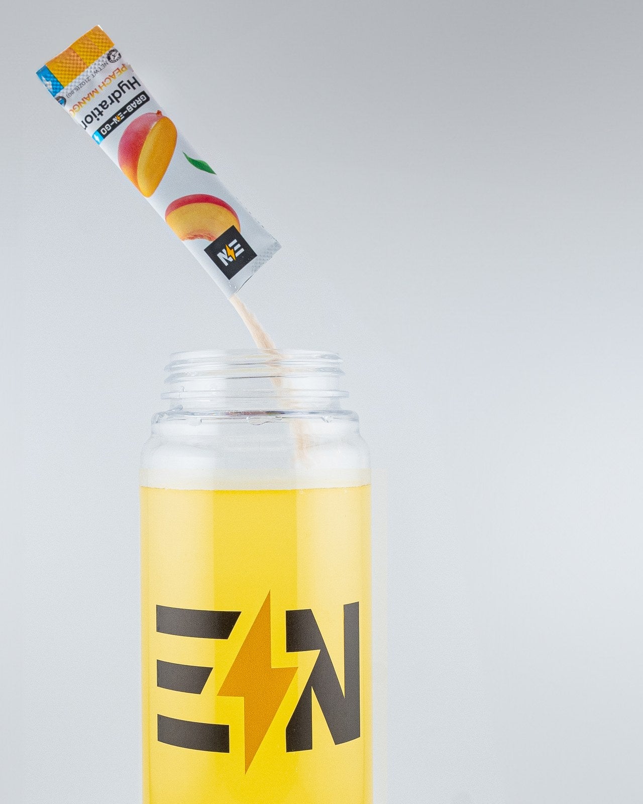 Engineered Nutrition Peach Mango hydration stick pouring into an EN bottle of water